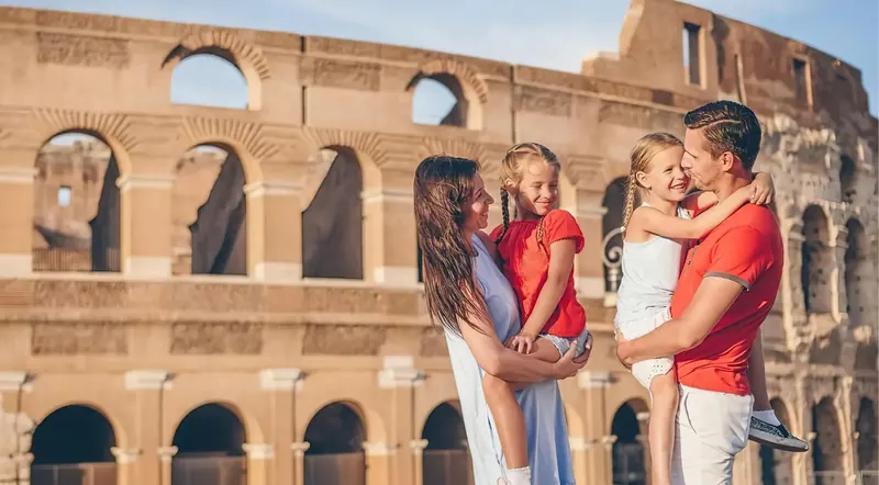 Family standing in front of the Colosseum in golden evening light