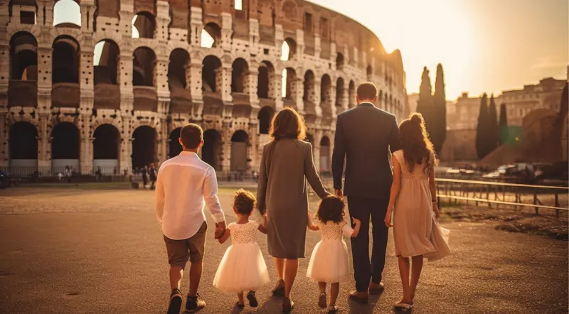 Large family holding hands walking toward the Colosseum at sunset